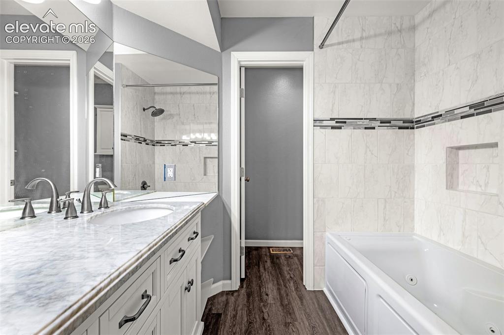 Image 18 of 49: Bathroom featuring a dual-sink vanity with a marble-finish countertop, whit