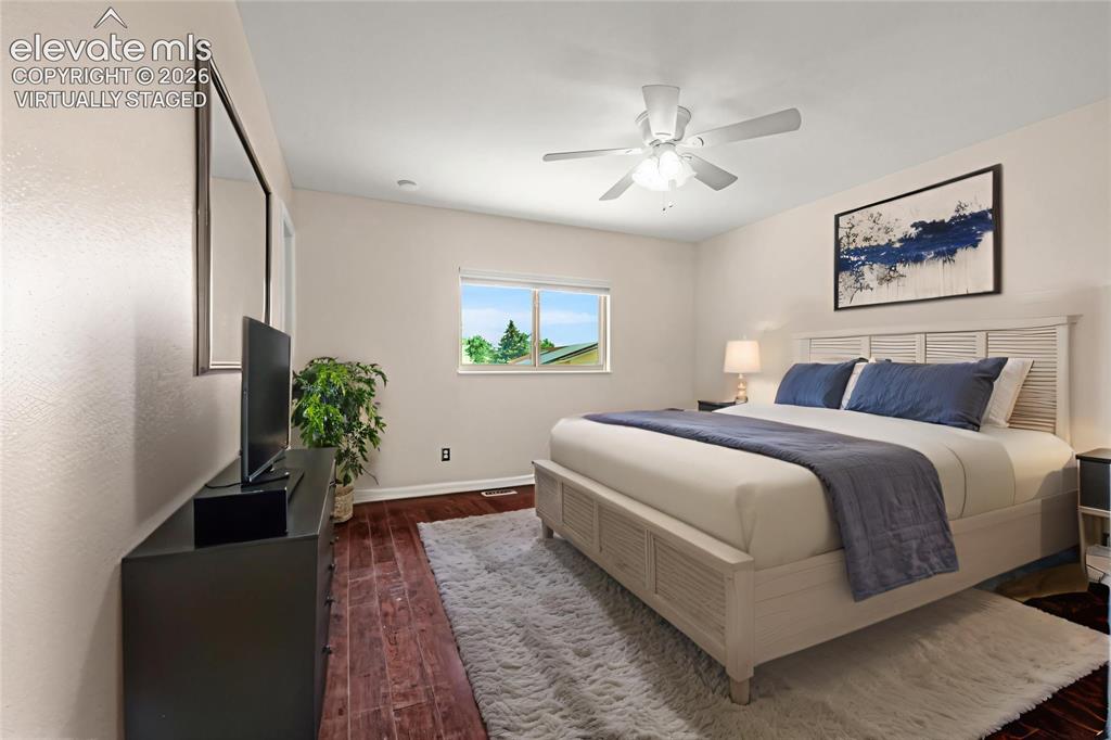 Image 21 of 49: Spacious room featuring rich wood-finish flooring, a ceiling fan with integ