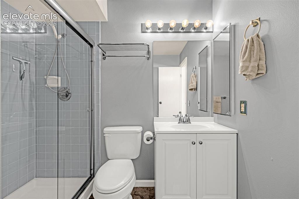 Image 22 of 49: Bathroom featuring a glass-enclosed shower with light blue tile, a white va