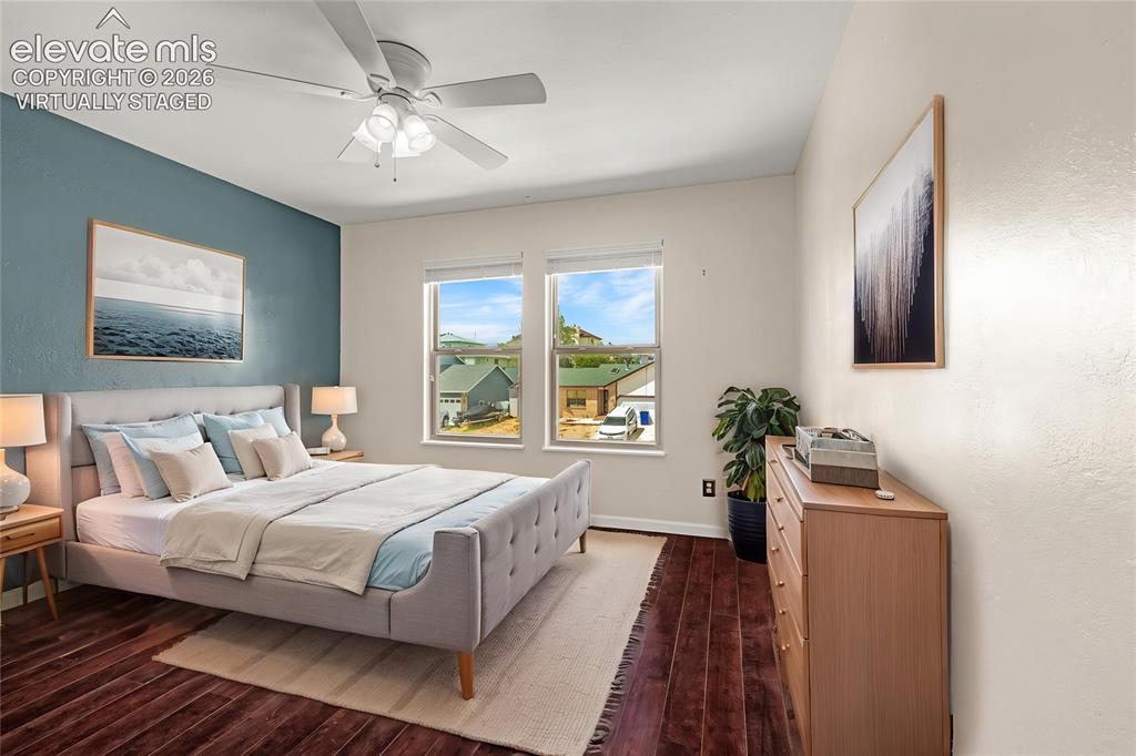 Image 23 of 49: Spacious room featuring rich wood-finish flooring, a ceiling fan with integ