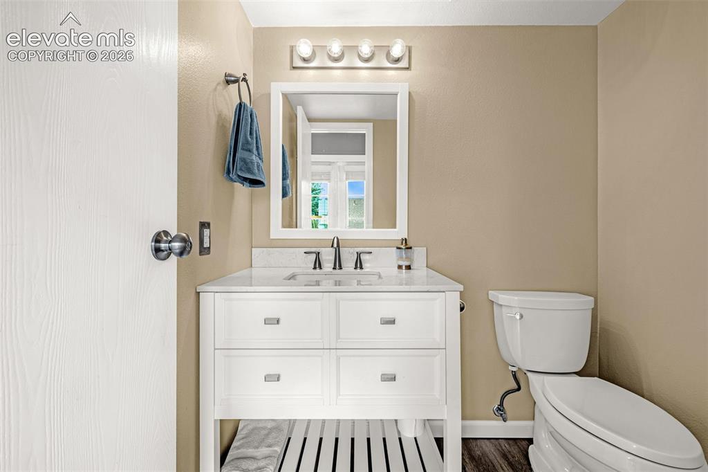 Image 27 of 49: Bathroom featuring a white vanity with a stone countertop, a rectangular mi