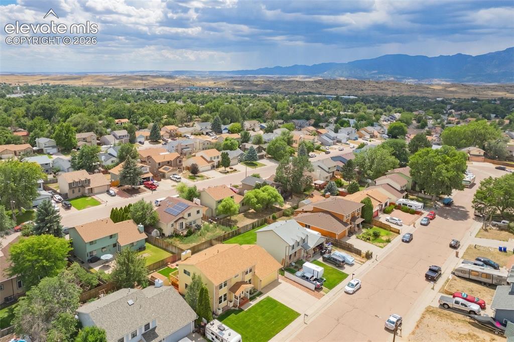 Image 32 of 49: Aerial view of a residential neighborhood with a mountainous backdrop