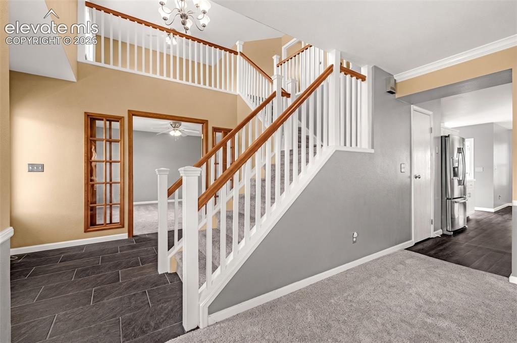 Image 36 of 49: Two-story foyer featuring a staircase with white balusters and wood-finish 
