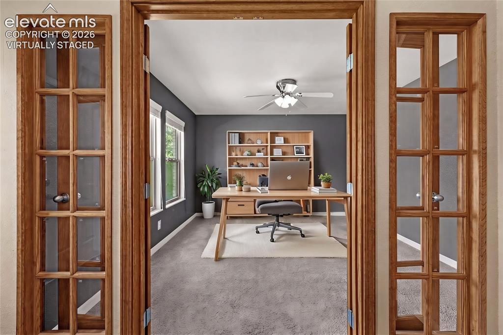 Image 4 of 49: Room featuring French doors with wood framing, dark gray accent wall, and t