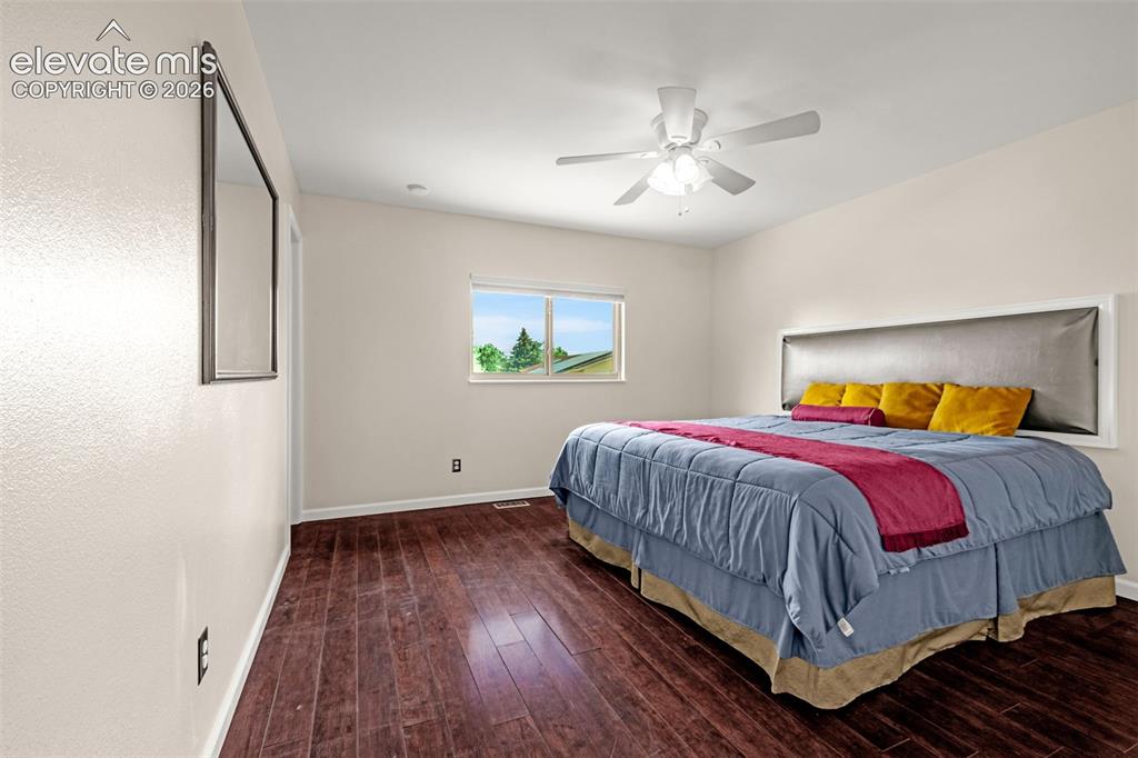 Image 44 of 49: Bedroom featuring wood-finish flooring, a contemporary window, and a ceilin