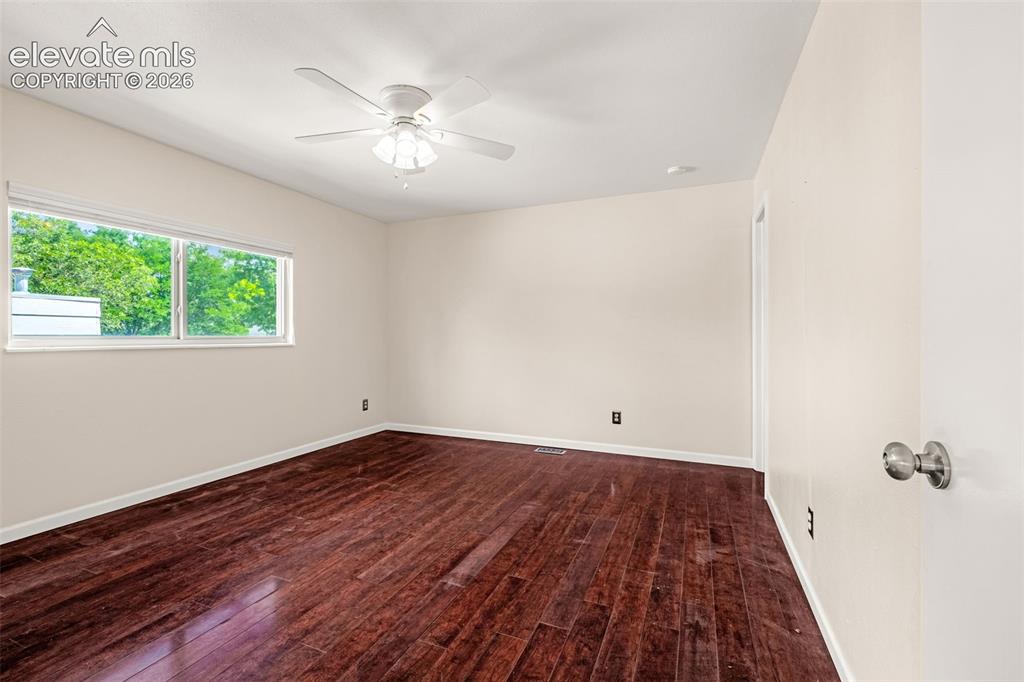 Image 45 of 49: Expansive room featuring wood-finish flooring, a ceiling fan with integrate