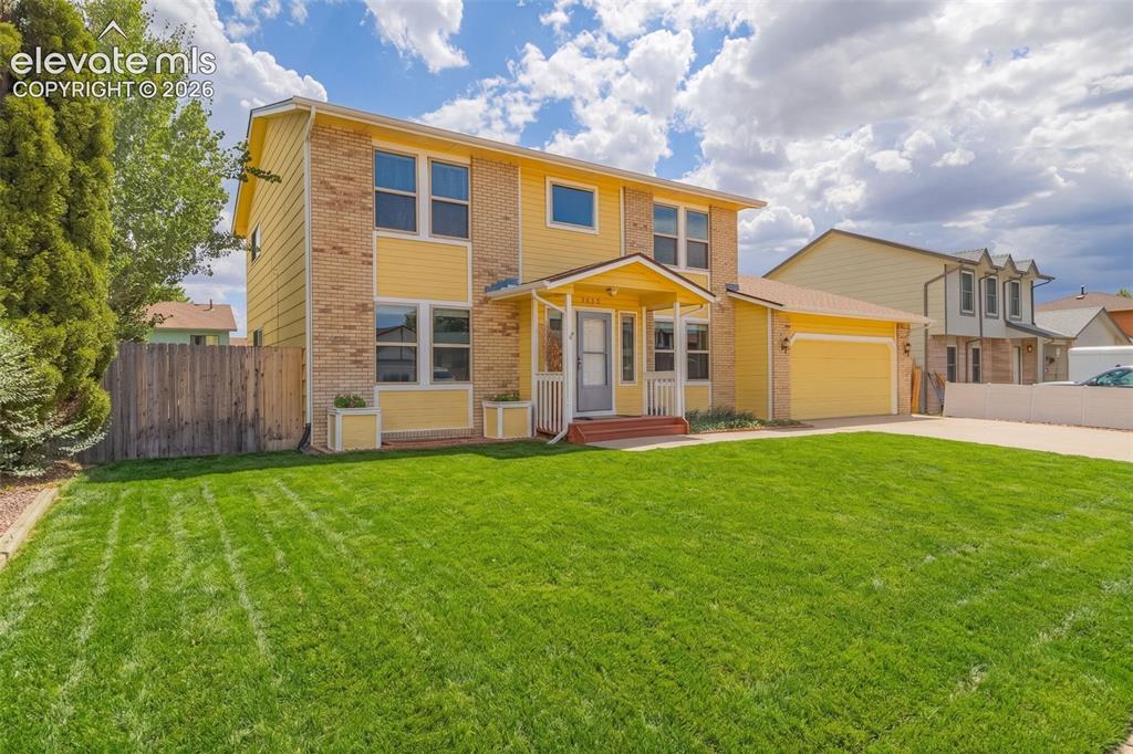Image 6 of 49: Two-story residence featuring yellow siding and brick accents