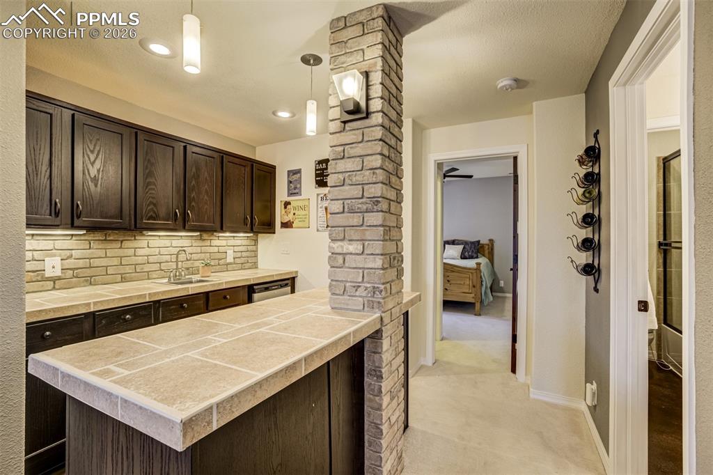 Image 31 of 50: Basement has a large wet bar with ample spae to entertain