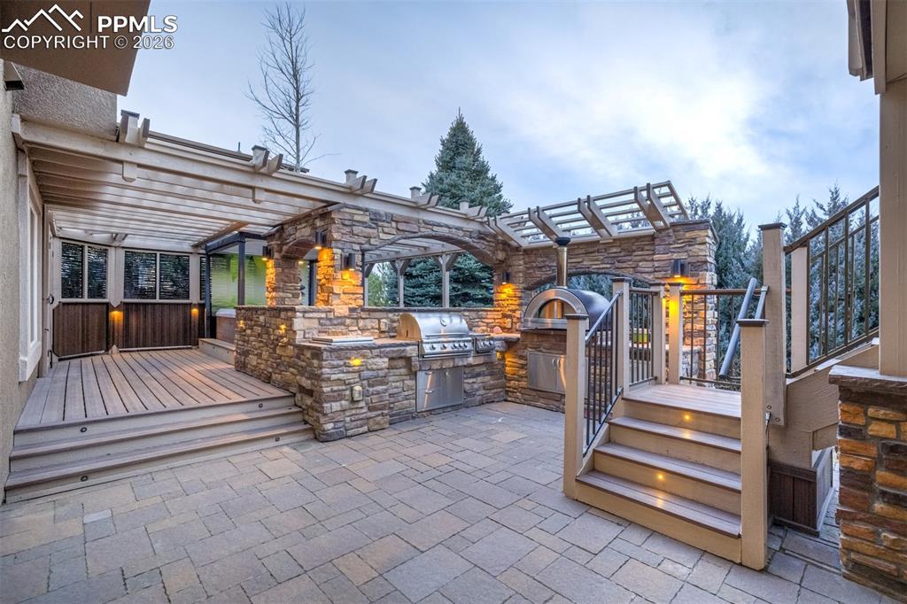 Image 40 of 50: Enjoy cooking in this lovely outdoor kitchen with stainless steel grill and