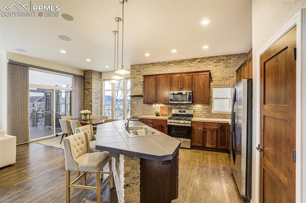 Image 9 of 50: A classic kitchen with bright lighting and island with counter seating, an 