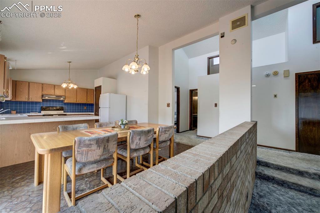 Image 10 of 50: The Living Room and Dining Area/Kitchen are divided by an attractive brick 