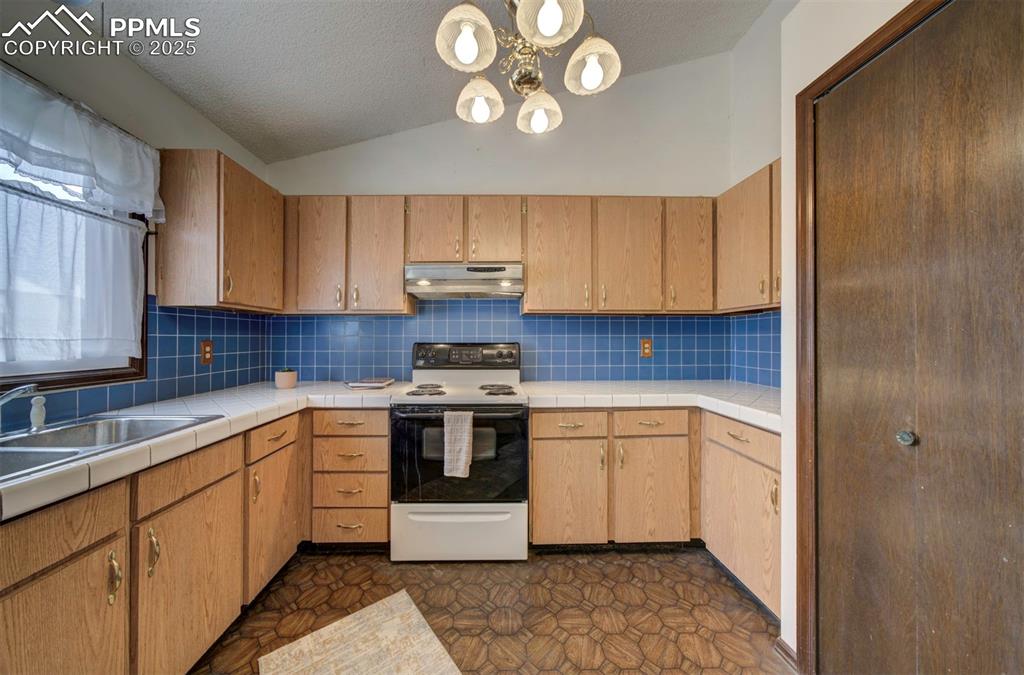 Image 16 of 50: Ample wood cabinets and counterspace for kitchen storage and easy food prep