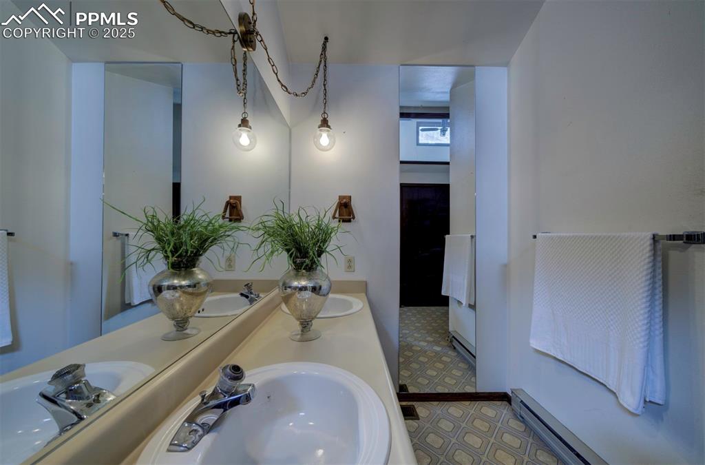 Image 23 of 50: Primary Bathroom with dual sink vanity and extended mirror.