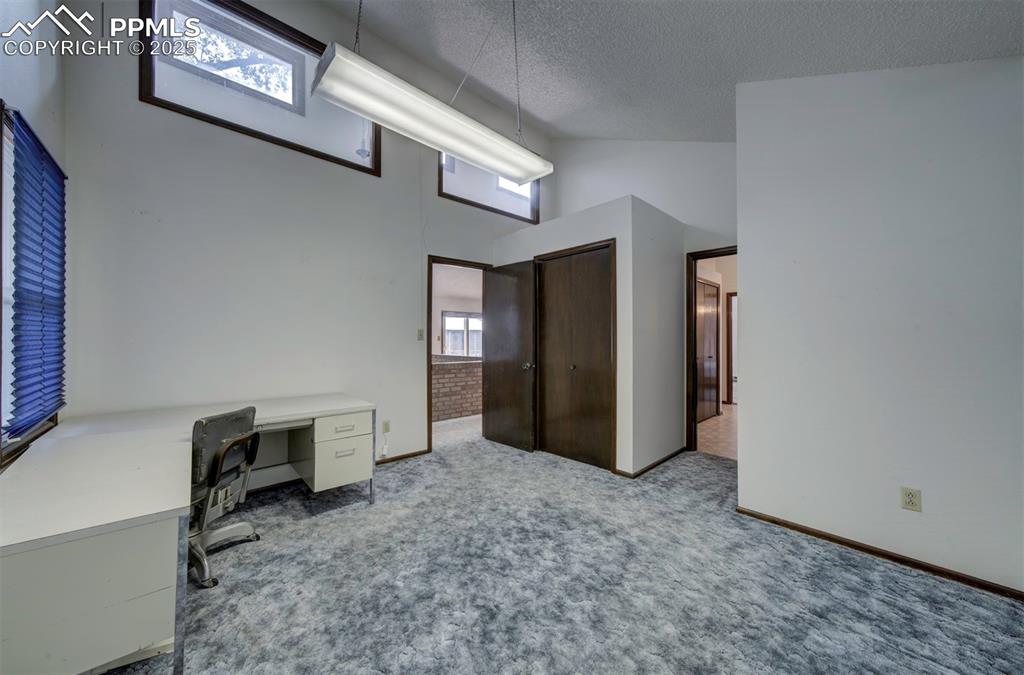 Image 28 of 50: Main level Bedroom #2 (currently an office) with carpet and adjoining bathr