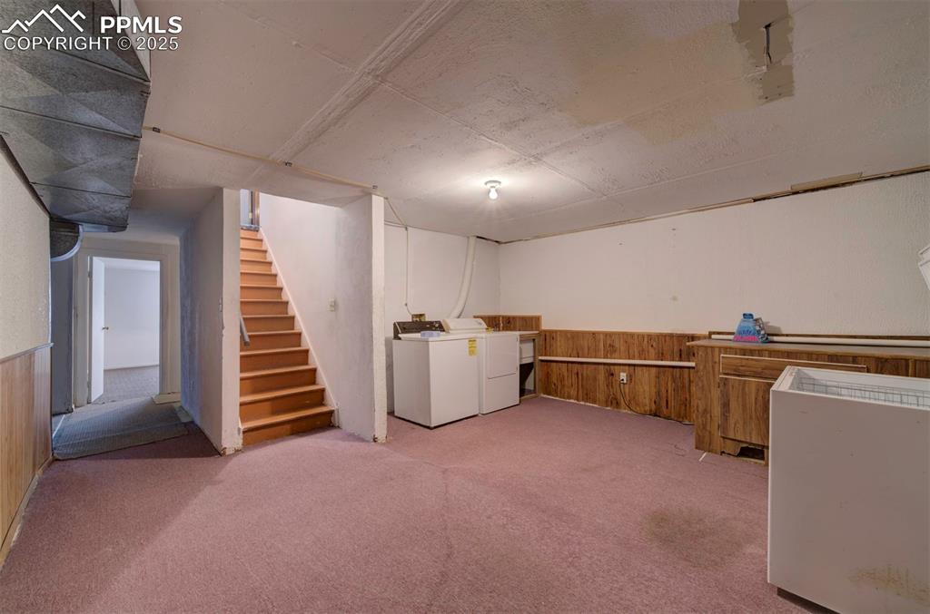 Image 31 of 50: Basement flex space with paneled wall and washer and dryer that stays.