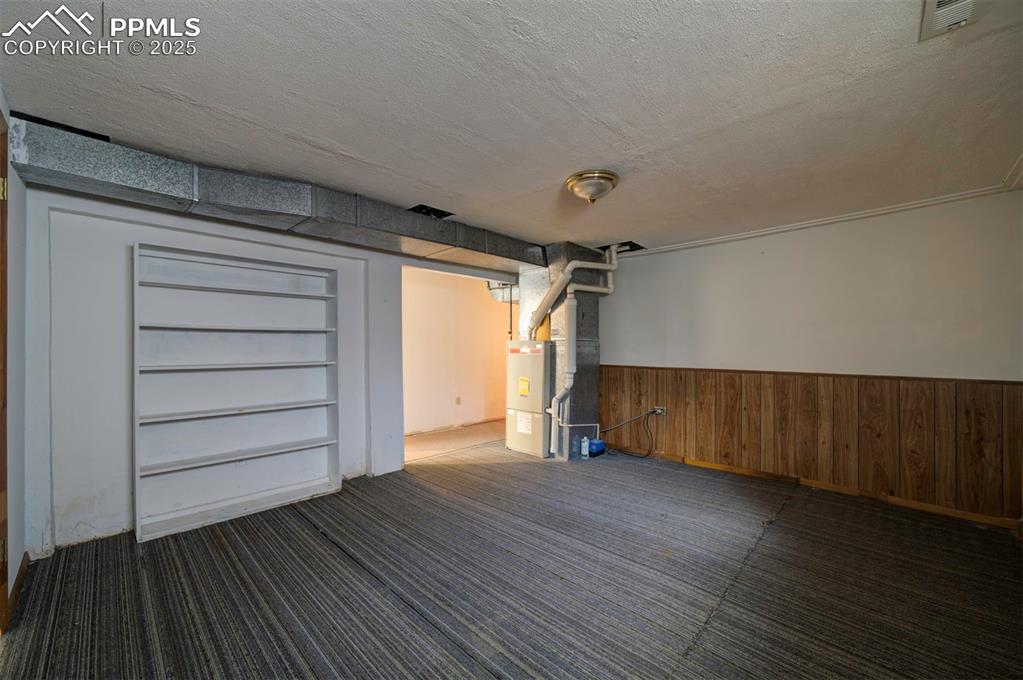 Image 38 of 50: Basement storage room with built-in shelves.