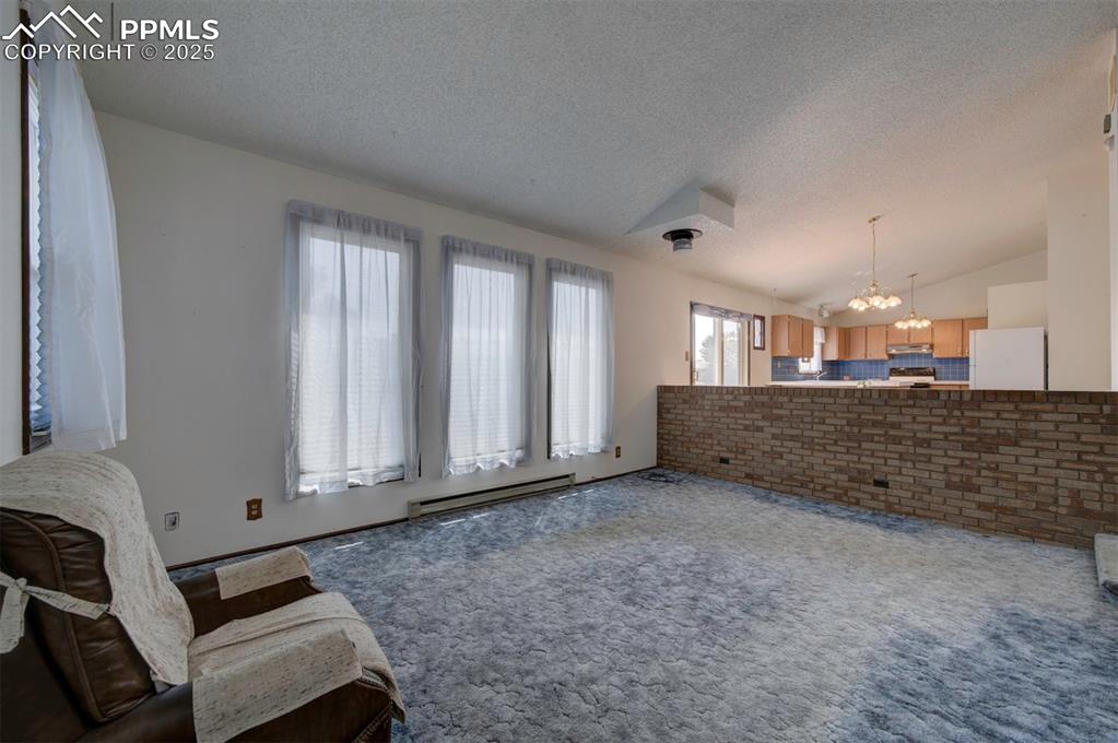 Image 8 of 50: The Living Room has a wall of windows that floods the room with natural sun