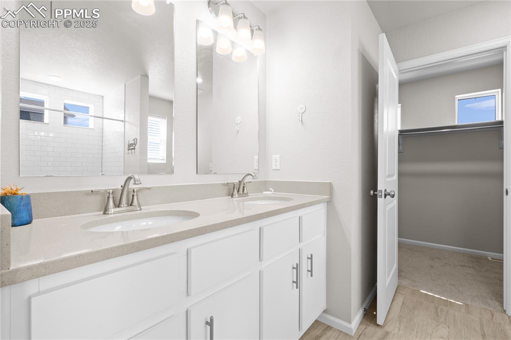 Image 15 of 26: Bathroom featuring a sink, double vanity, and a healthy amount of sunlight