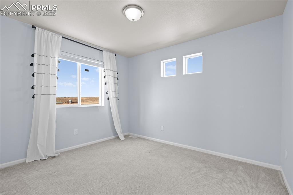 Image 19 of 26: Empty room featuring baseboards and light carpet