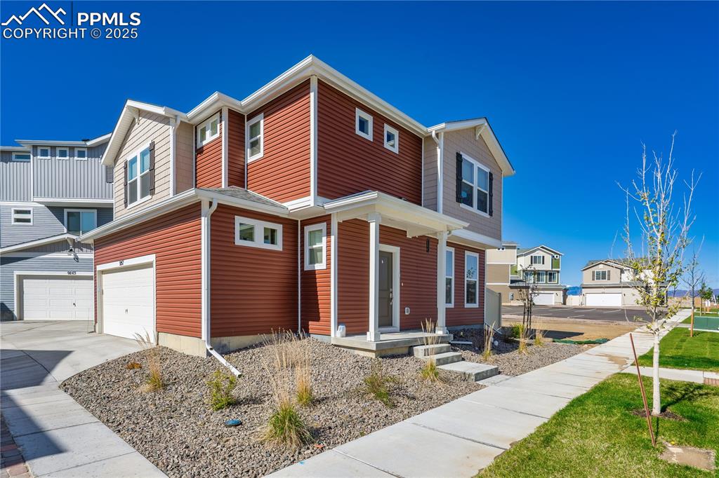 Image 2 of 26: View of front of home featuring a garage, concrete driveway, and a resident
