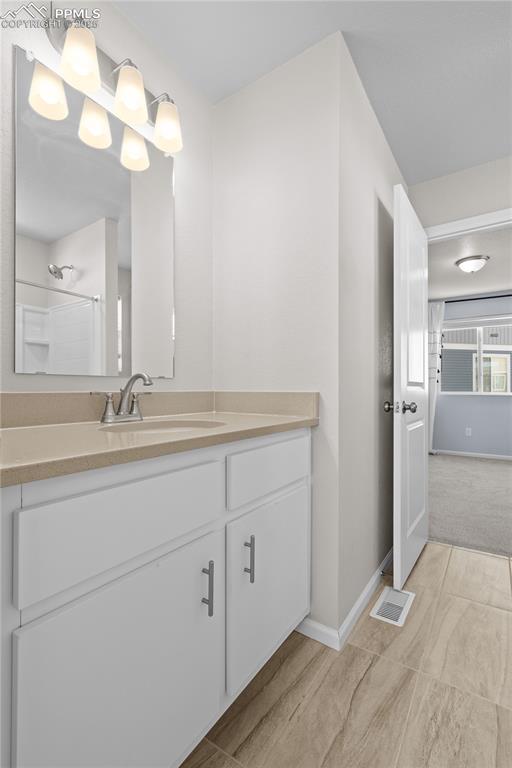 Image 22 of 26: Full bath with vanity, baseboards, and a shower