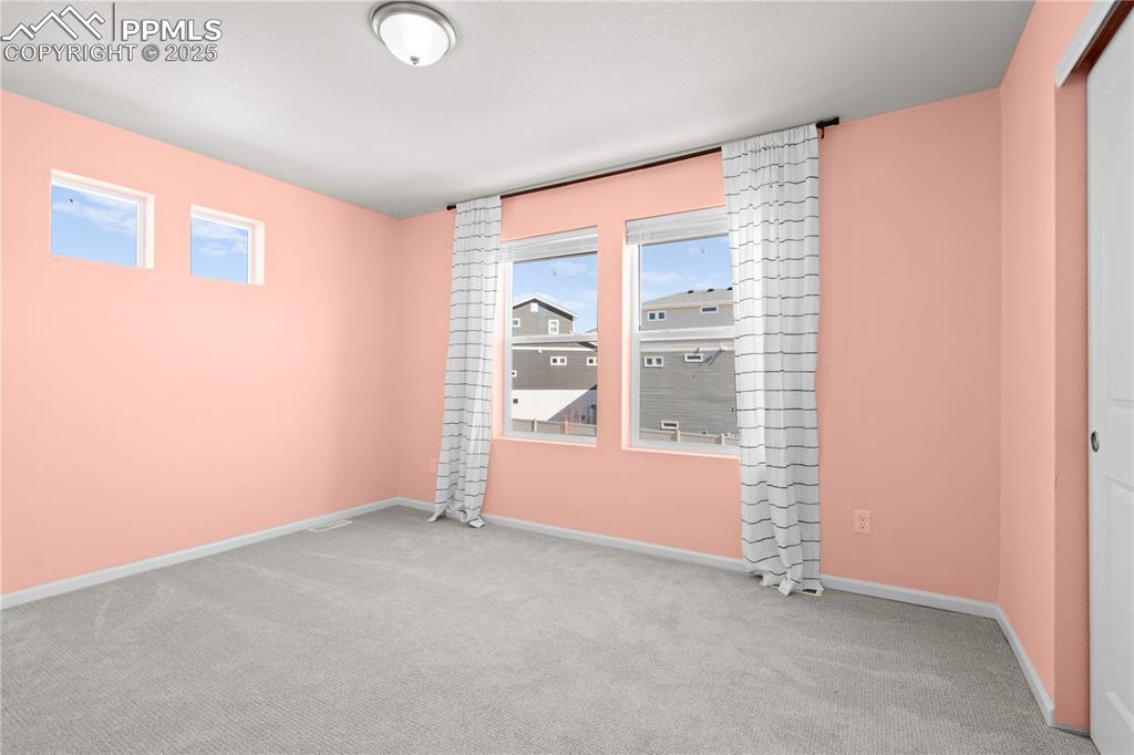 Image 24 of 26: Carpeted spare room featuring baseboards and a healthy amount of sunlight