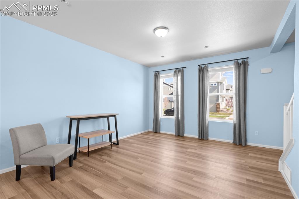 Image 8 of 26: Sitting room with light wood-style floors and baseboards