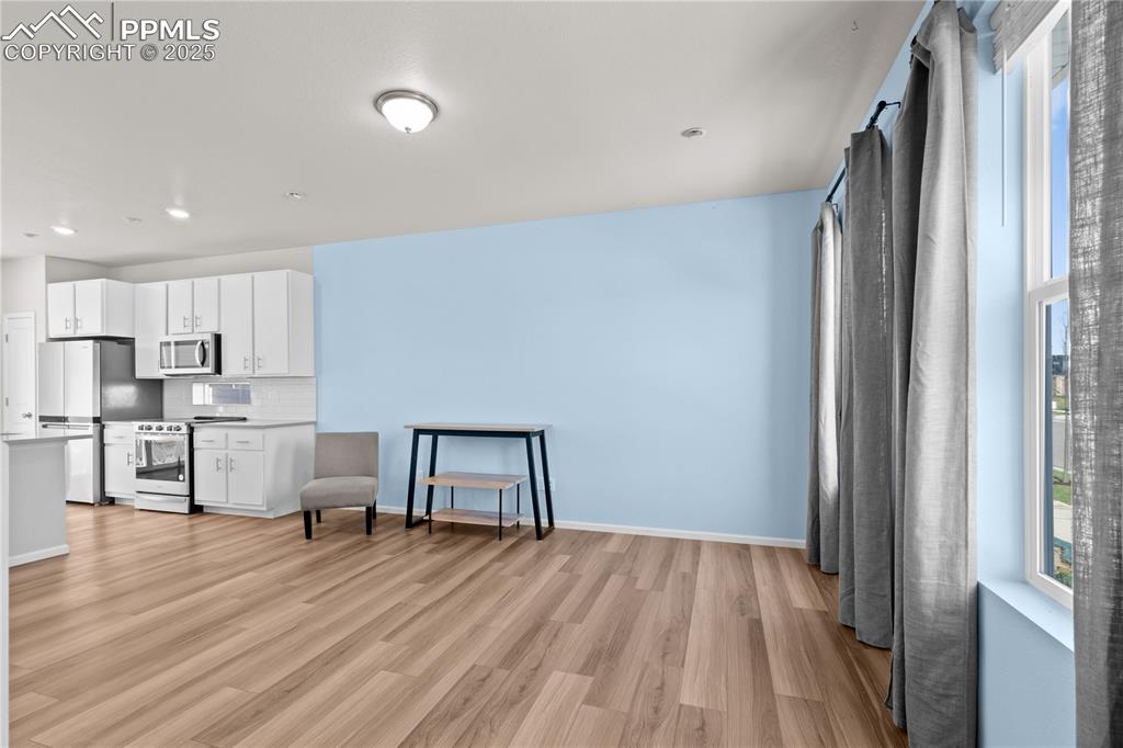 Image 9 of 26: Living area featuring recessed lighting, baseboards, and light wood-type fl
