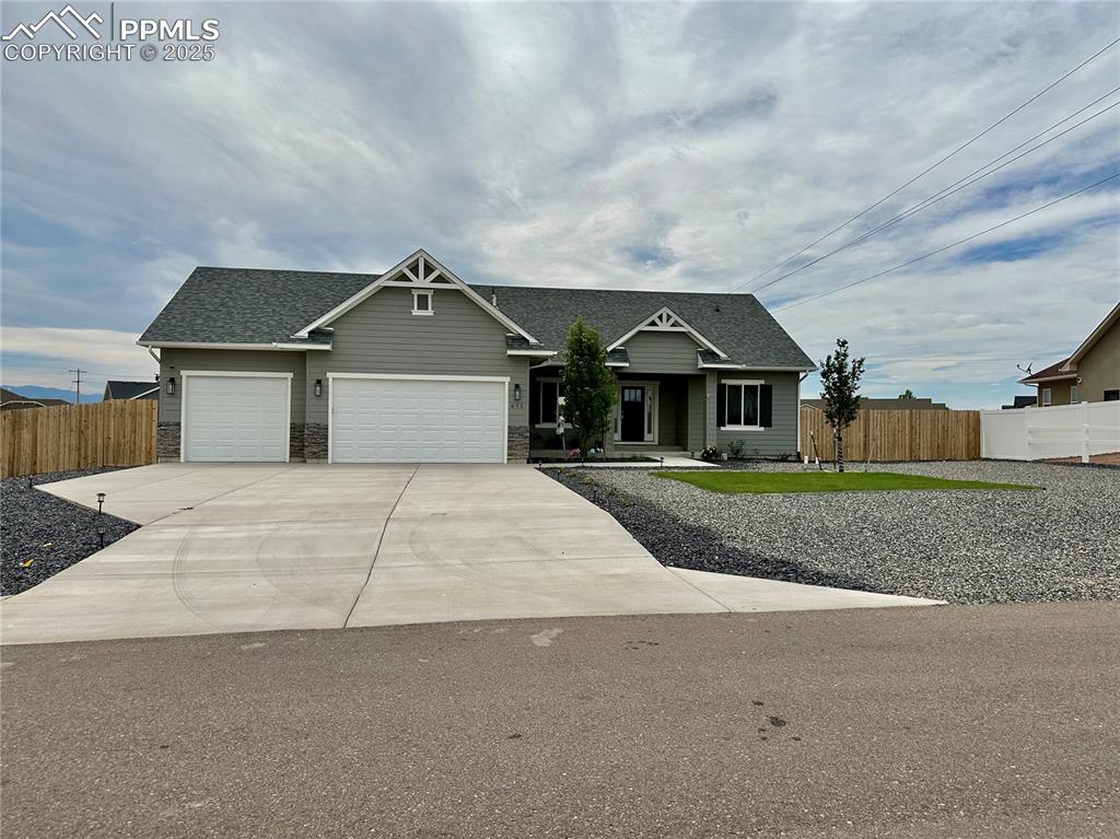 Caption: Craftsman-style home featuring roof with shingles, a garage, concrete driveway, and stone siding