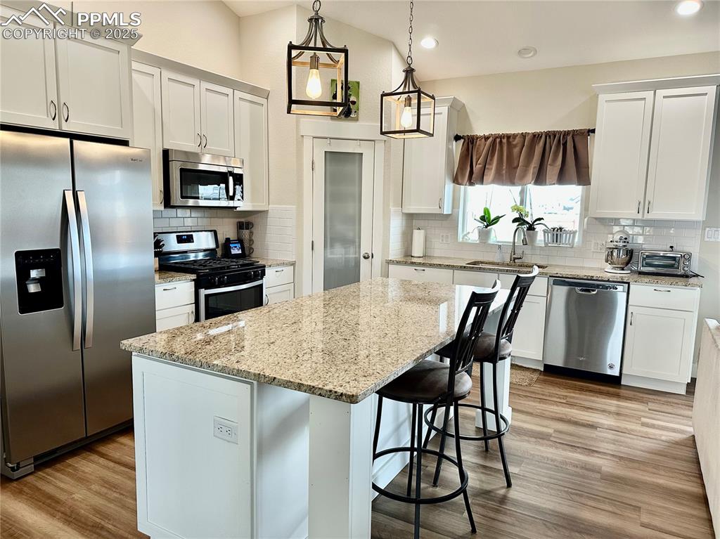 Image 10 of 38: Kitchen with appliances with stainless steel finishes, tasteful backsplash,
