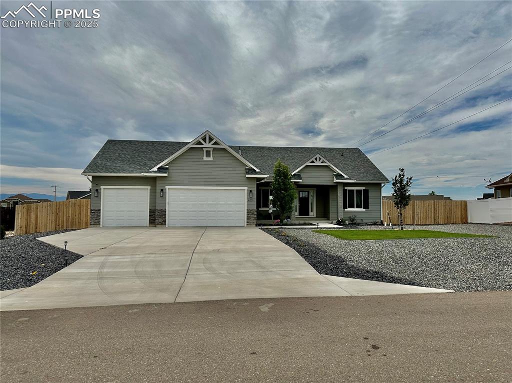 Image 2 of 38: Craftsman-style home featuring a shingled roof, a garage, and concrete driv