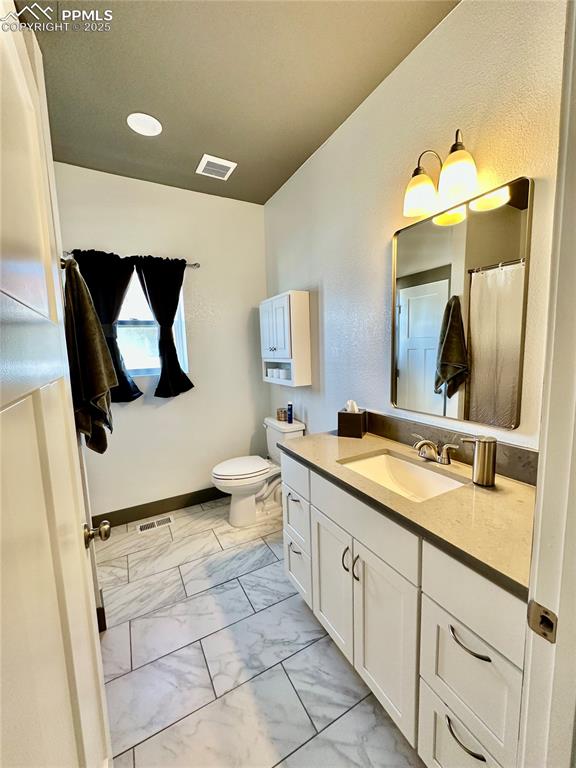 Image 24 of 38: Bathroom featuring vanity and light marble finish flooring