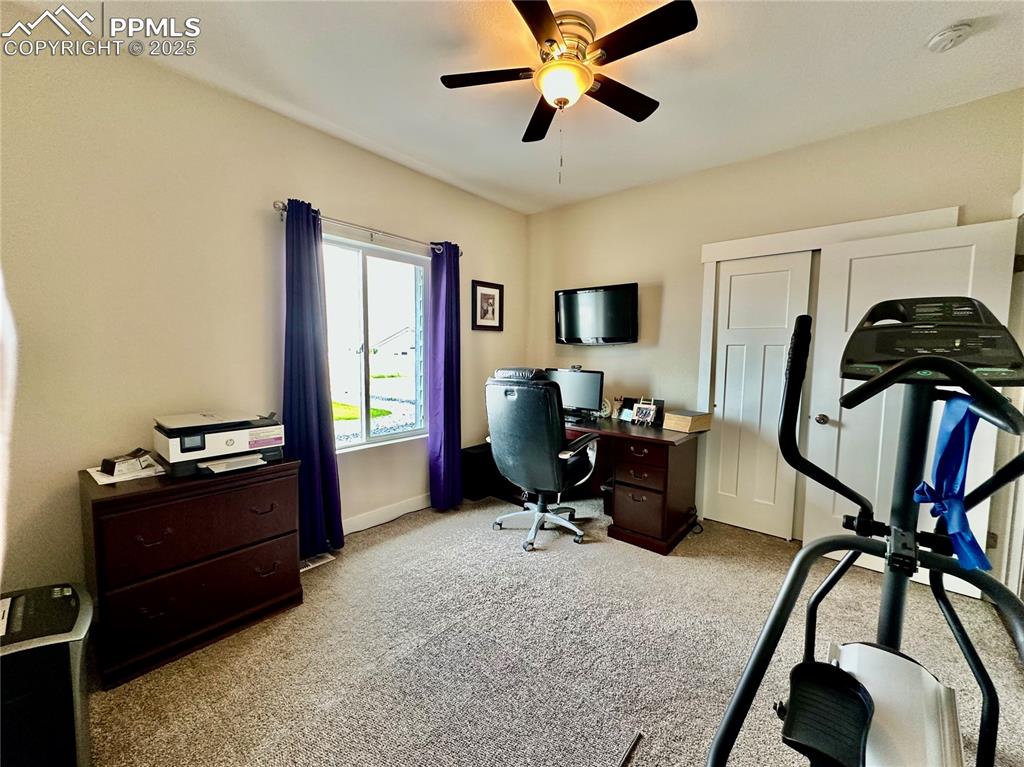 Image 26 of 38: Office space featuring light colored carpet and a ceiling fan