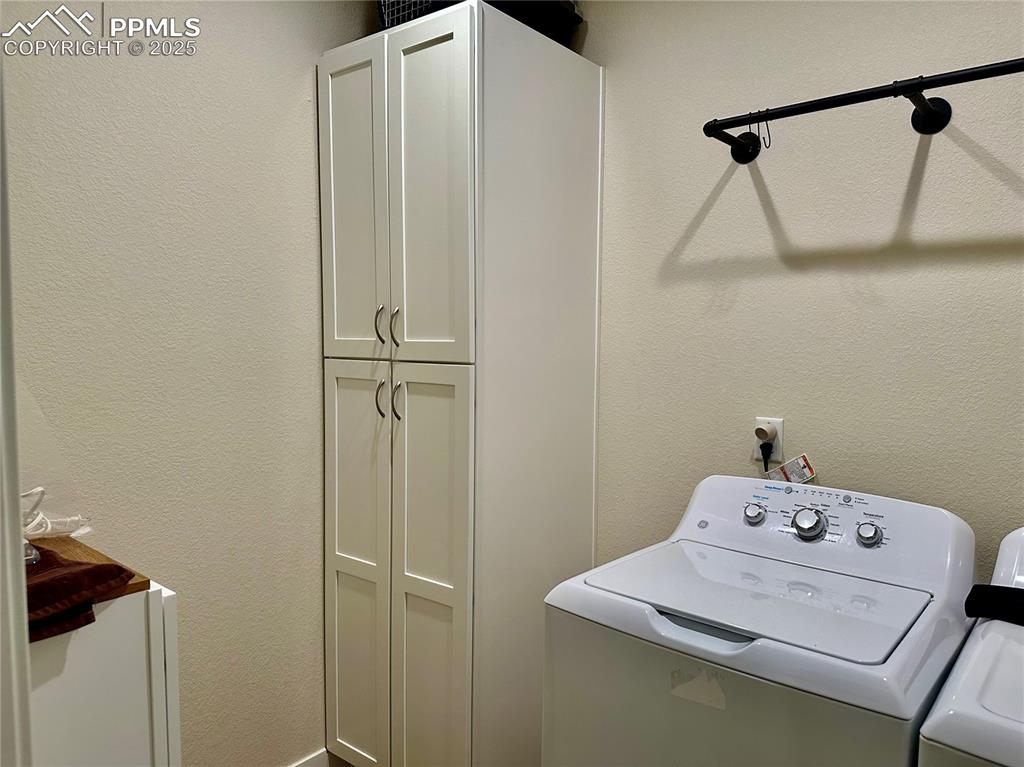 Image 27 of 38: Washroom with a textured wall and cabinet space