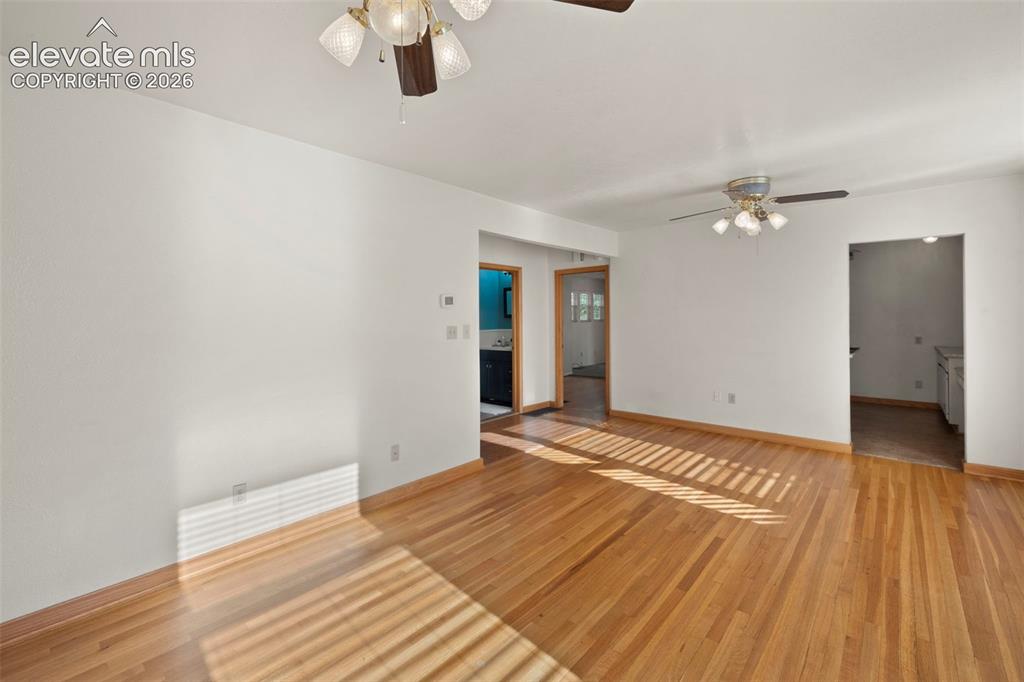 Image 11 of 44: Hardwood flooring, white walls, and ceiling fans with integrated lighting