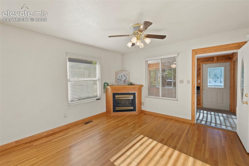 Image 14 of 44: Wood-finish flooring throughout, corner fireplace, windows with blinds, cei