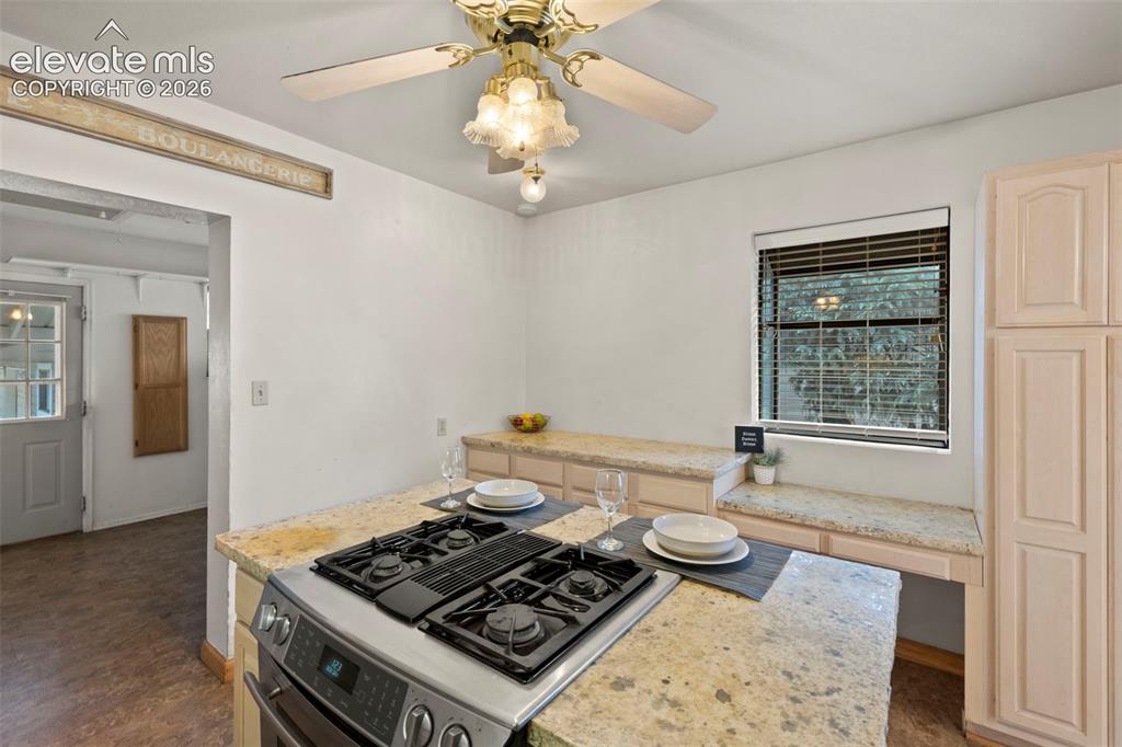 Image 22 of 44: Granite countertops, built-in cooktop, light wood-finish cabinetry, ceiling