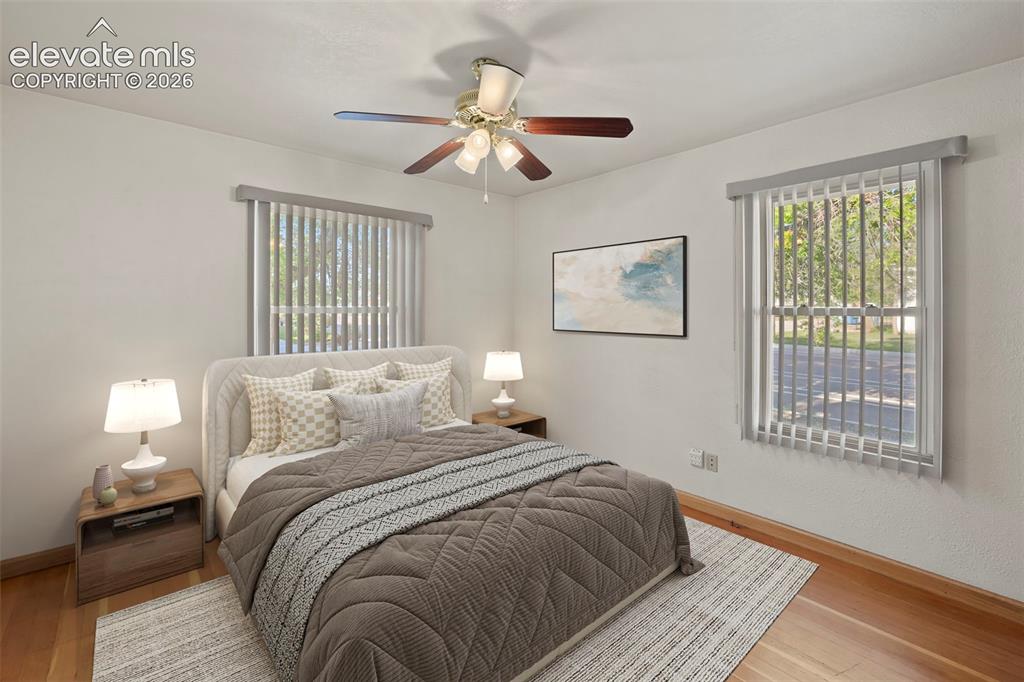 Image 23 of 44: Wood-finish flooring, two windows with vertical blinds, and a ceiling fan w