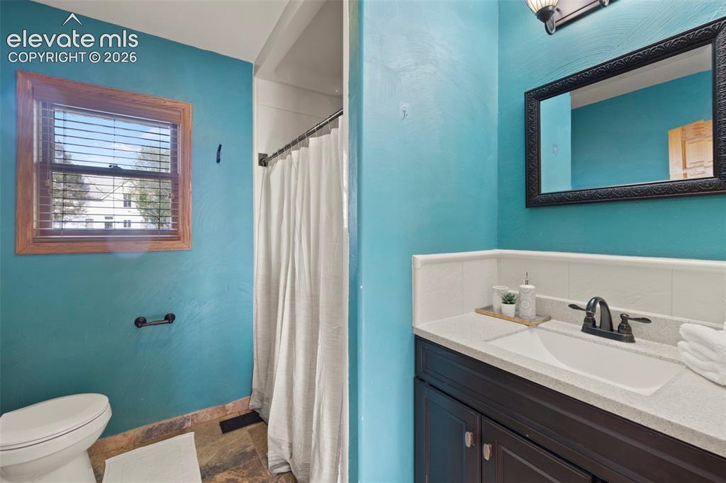 Image 27 of 44: Bathroom featuring a wood-framed window, tile flooring, and a vanity with a