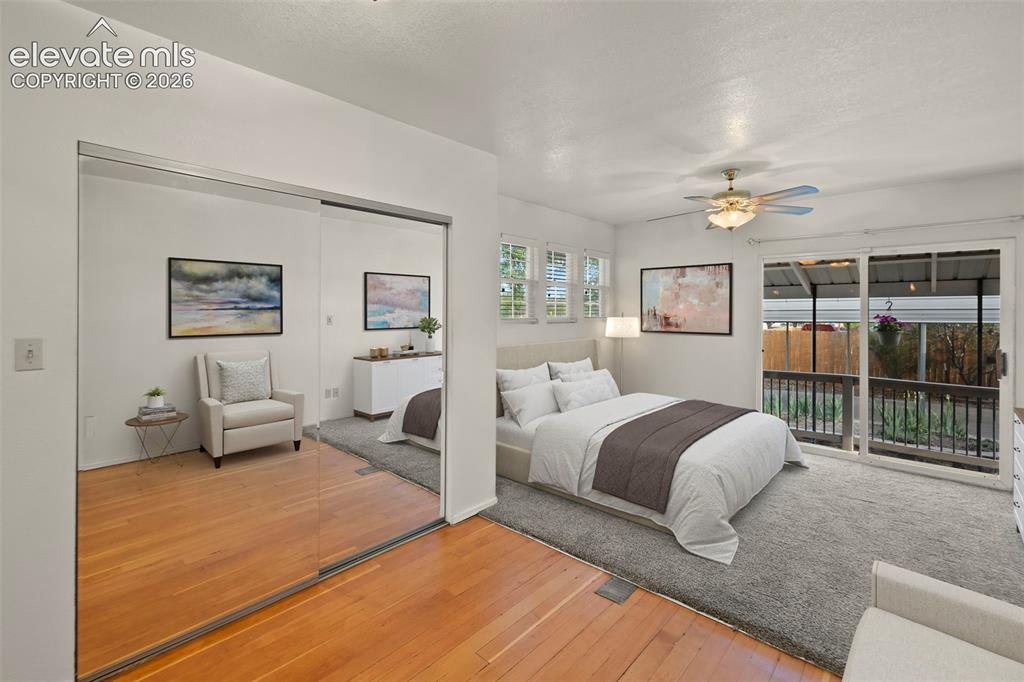 Image 28 of 44: Wood-finish flooring, mirrored sliding doors, ceiling fan, multiple windows