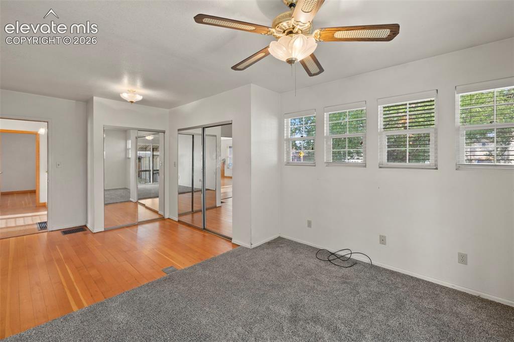 Image 30 of 44: Recessed lighting, ceiling fan light fixture, wood-finish flooring, mirrore