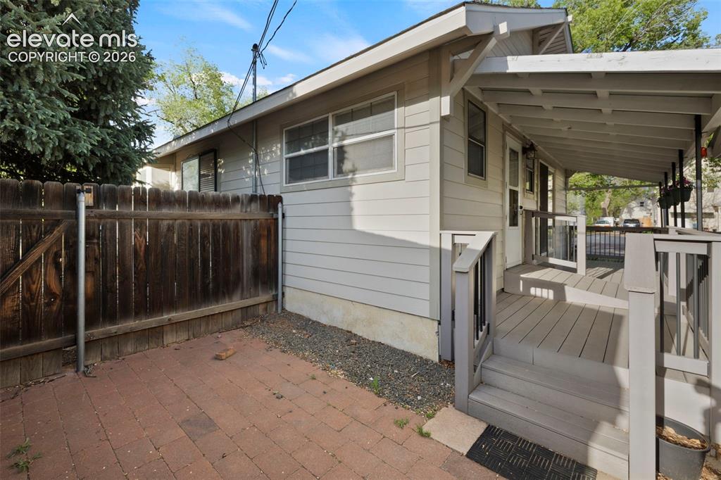 Image 40 of 44: Covered porch with wood-finish decking and railing system