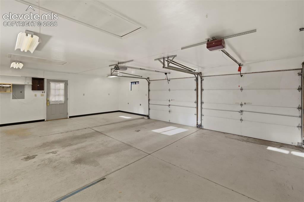 Image 44 of 44: Two-car garage with concrete flooring, two overhead garage doors, and overh