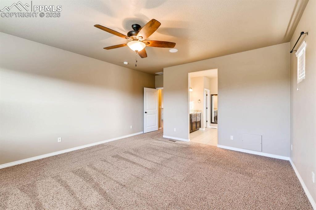 Image 14 of 28: Unfurnished bedroom with connected bathroom, light colored carpet, and a ce