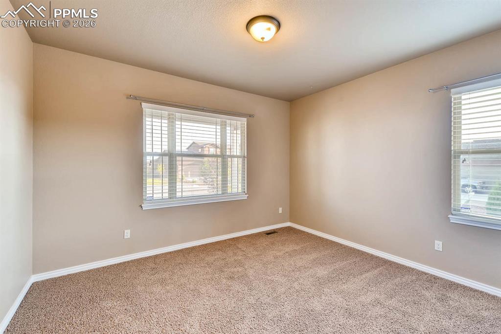 Image 18 of 28: Spare room with baseboards and light carpet