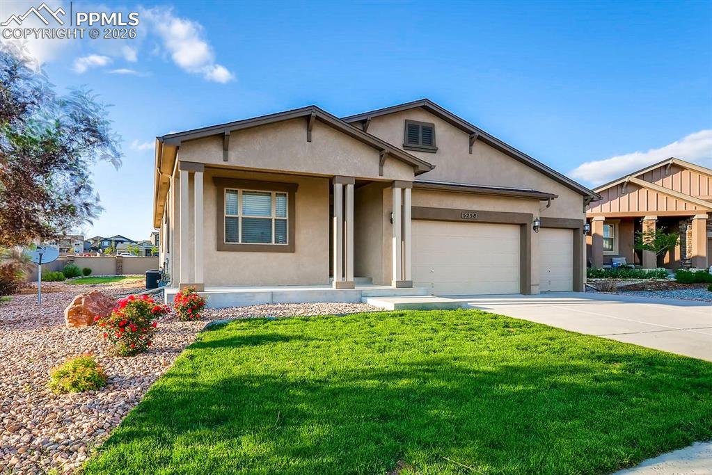 Image 2 of 28: View of front facade featuring a garage, stucco siding, a front lawn, a por