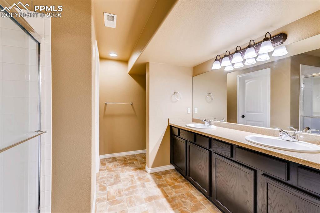 Image 22 of 28: Full bath with a stall shower, double vanity, and recessed lighting