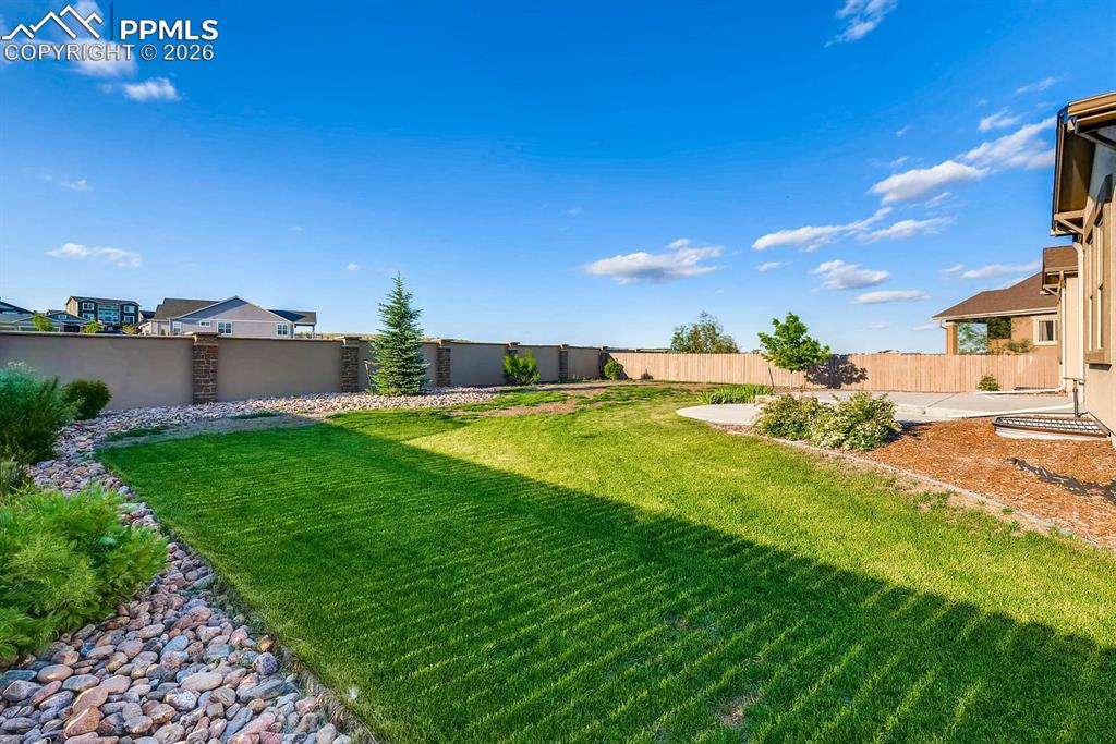 Image 26 of 28: Fenced backyard with a patio