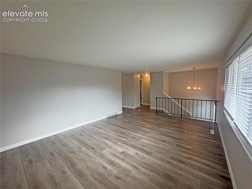Image 10 of 42: Open-concept living space featuring wood-finish flooring, neutral wall pain