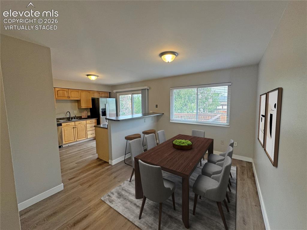 Image 11 of 42: virtually staged Kitchen featuring wood cabinetry, integrated breakfast bar